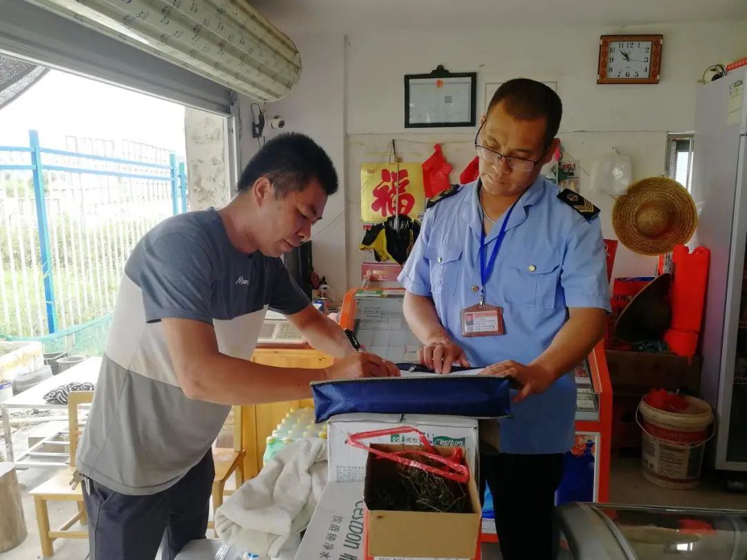 圖為許杰華（右一）到偏遠(yuǎn)農(nóng)村個(gè)體經(jīng)營戶中開展食品安全檢查工作